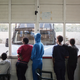 A group of minors from Eritrea look out the window in the door of the CPSA (Centro di primo soccorso ed accoglienza) in Pozzallo, which is blocked by a police van to prevent people from escaping.